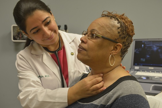 female endocrine specialist checking thyroid glad enlargement in a female patient