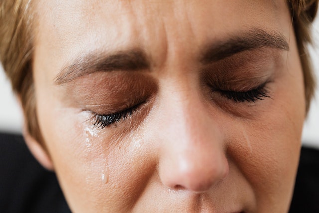 Middle aged woman sobbing tears due to mental health issues