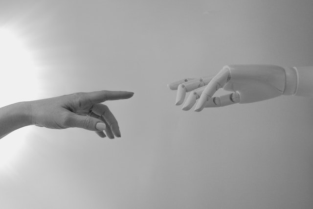 A robot android hand reaching out to a human hand